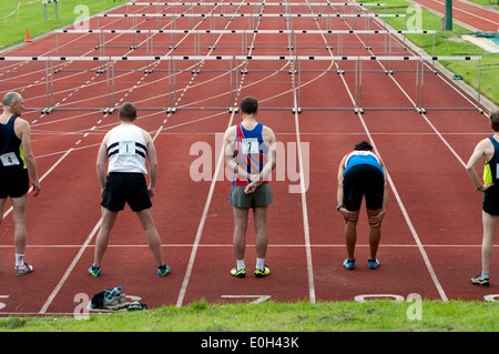 Athletics, runners at start of men`s 110m hurdles race at club level, UK Stock Photo